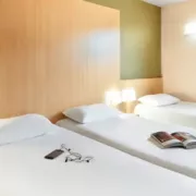 Chambre avec trois lits simples de l'hôtel B&B à Perpignan Nord.