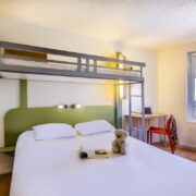 Chambre avec un lit double et un lit suspendu de l'hôtel Ibis Budget à Limoges