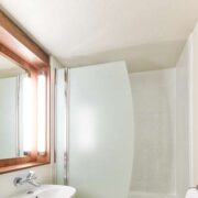 Salle de bain équipé d'une baignoire douche, lavabo et toilette de l'hôtel Campanile de Perpignan.